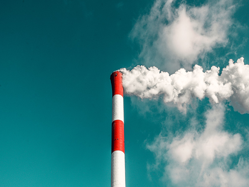 Red and white tower with smoke coming out of the top