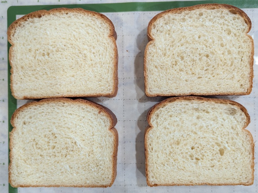 Four sliced pieces of bread displayed on a pan.